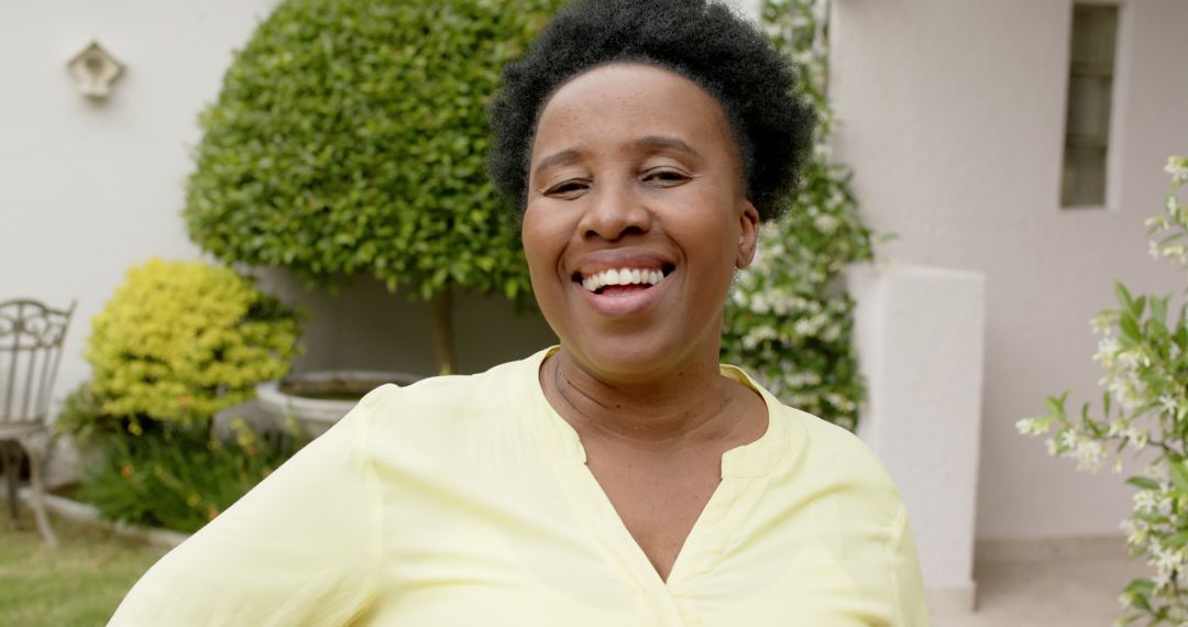 Smiling African American Woman Standing in Front of a Garden - Free Images, Stock Photos and Pictures on Pikwizard.com