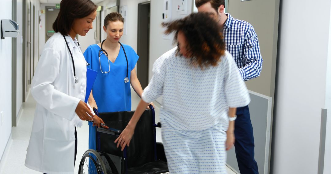 Doctors and Nurses Assisting Patient in Hospital Corridor with Wheelchair - Free Images, Stock Photos and Pictures on Pikwizard.com