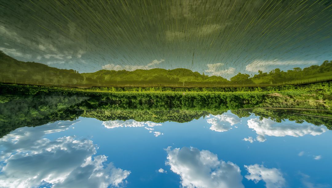 Serene Water Reflections of Hills and Dramatic Clouds in Rural Setting