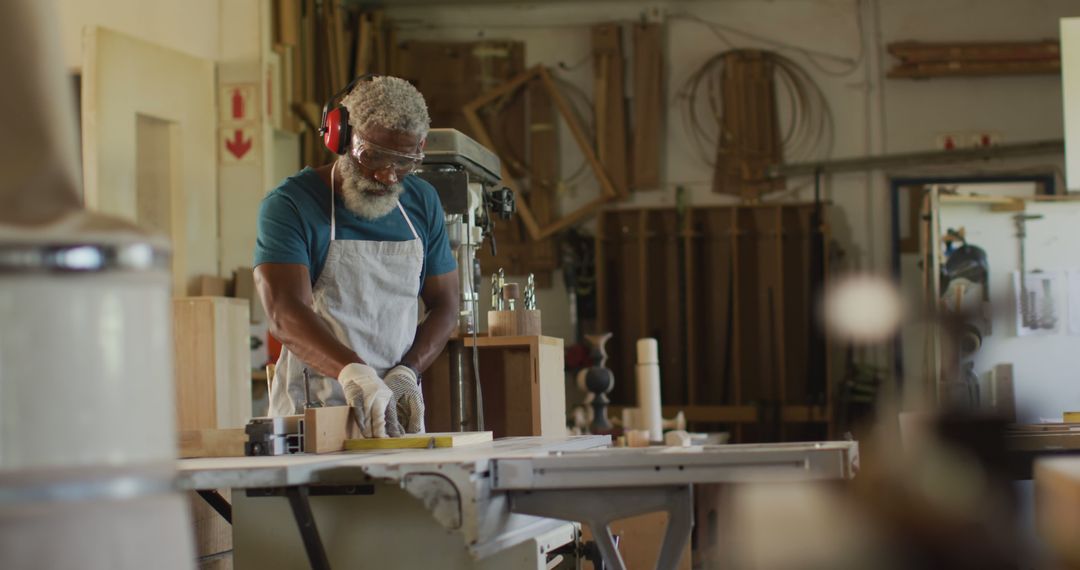 African american male carpenter using table saw for cutting wood at a carpentry shop - Free Images, Stock Photos and Pictures on Pikwizard.com