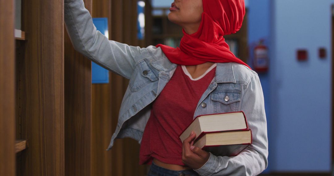 Female Student in Red Hijab Searching Books in Library - Free Images, Stock Photos and Pictures on Pikwizard.com