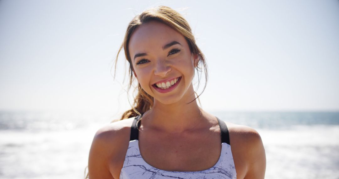 Healthy Woman Smiling at Beach in Athletic Wear - Free Images, Stock Photos and Pictures on Pikwizard.com