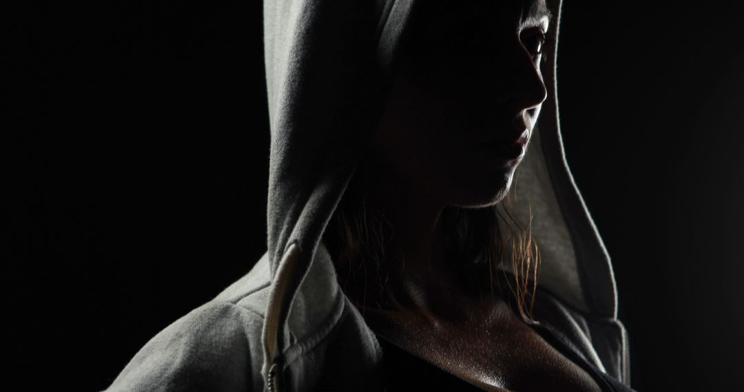 Portrait of focused caucasian strong woman in grey hoodie with copy space on black background - Free Images, Stock Photos and Pictures on Pikwizard.com
