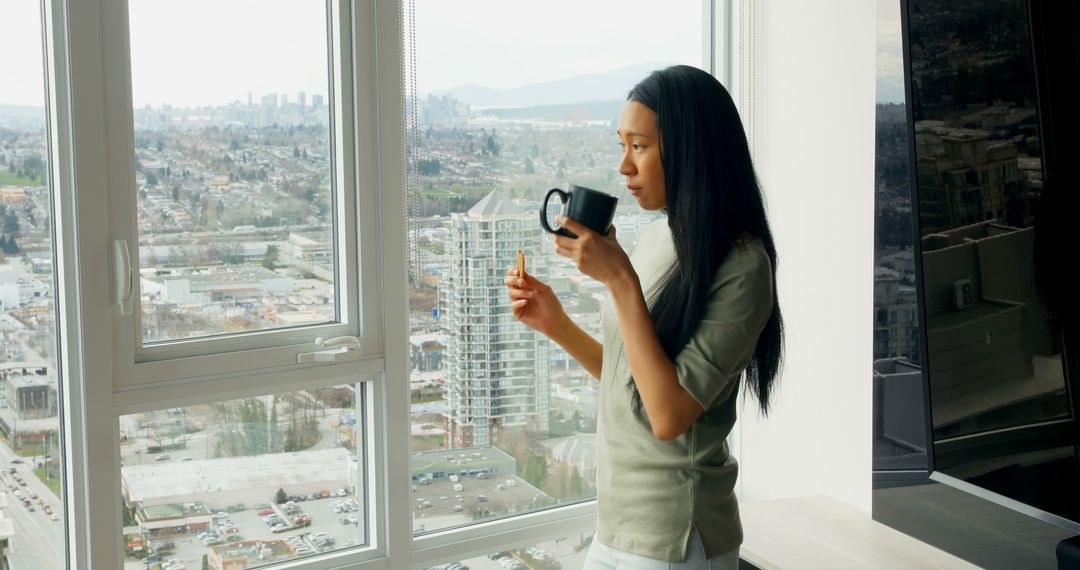 Woman Enjoying Coffee by Window Overlooking Cityscape - Free Images, Stock Photos and Pictures on Pikwizard.com