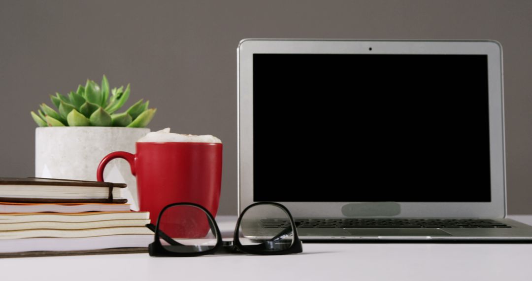 Modern Workspace with Laptop, Coffee Mug, Books, Eyeglasses and Succulent Plant - Free Images, Stock Photos and Pictures on Pikwizard.com