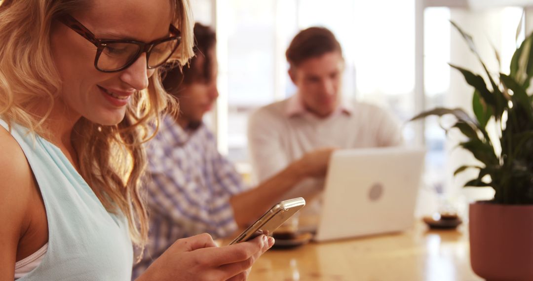 Smiling Woman Enjoying Mobile Technology in Cafe