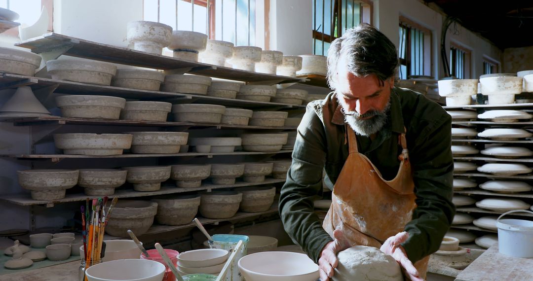 Experienced Artisan Shaping Clay on Pottery Wheel in Studio