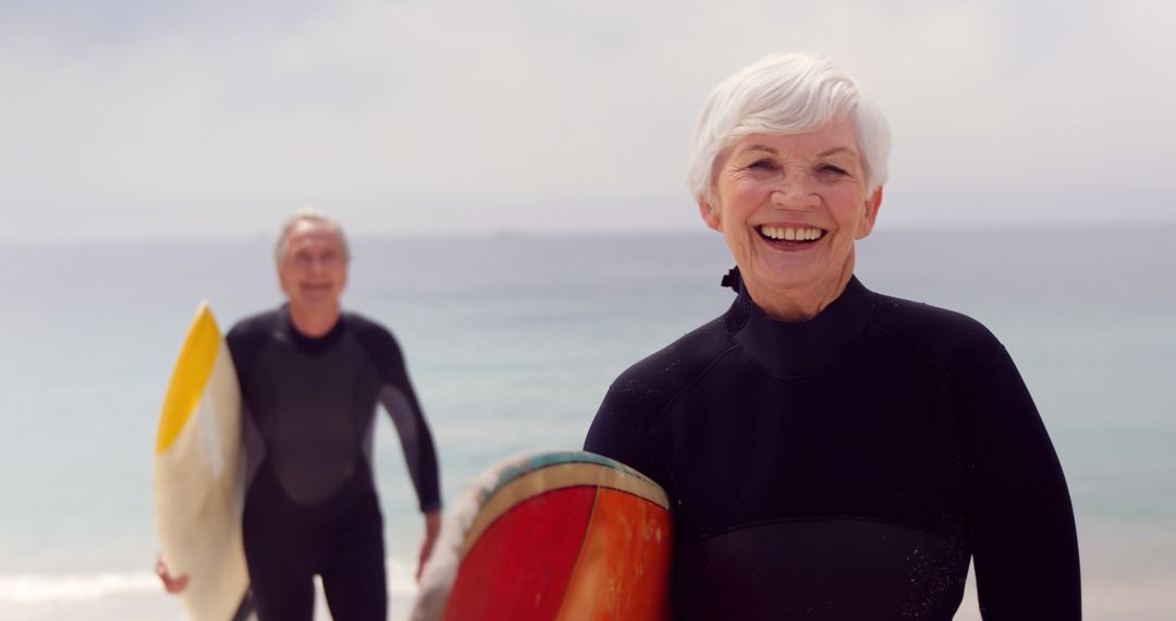 An elderly couple enjoys surfing together, embodying vitality in their golden years. - Free Images, Stock Photos and Pictures on Pikwizard.com