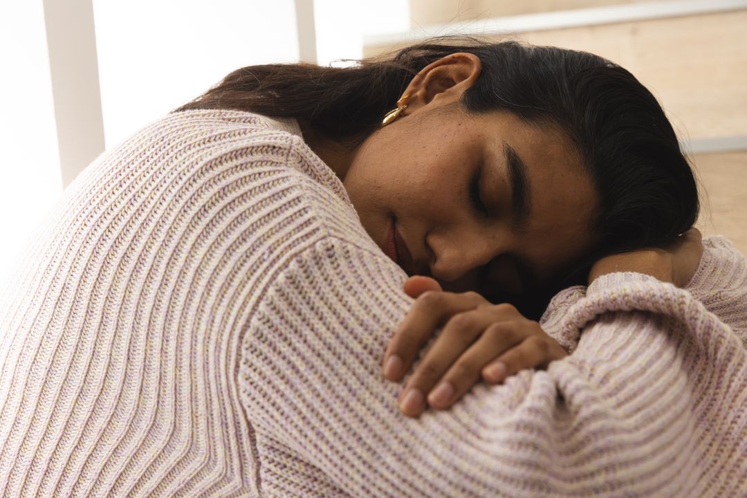 Woman Finding Solace Leaning on Wooden Steps by Sunlit Window