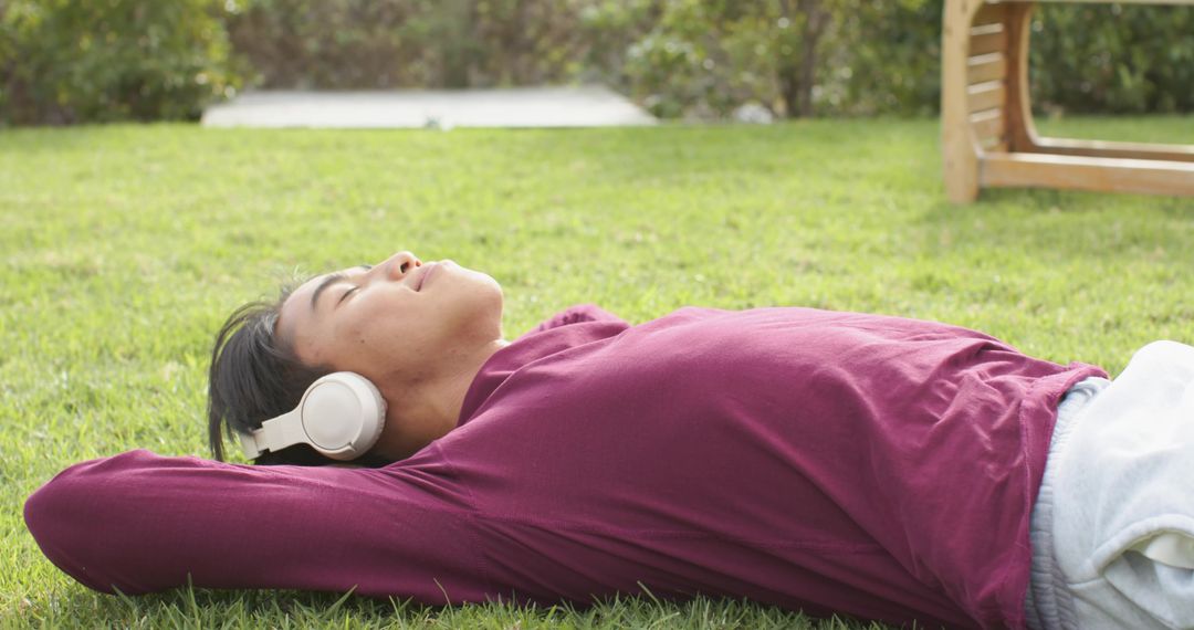 Man Relaxing on Grass with Headphones Enjoying Nature