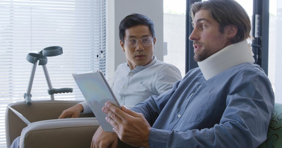 Doctor Discussing Recovery Plan with Injured Patient Wearing Neck Brace - Free Images, Stock Photos and Pictures on Pikwizard.com