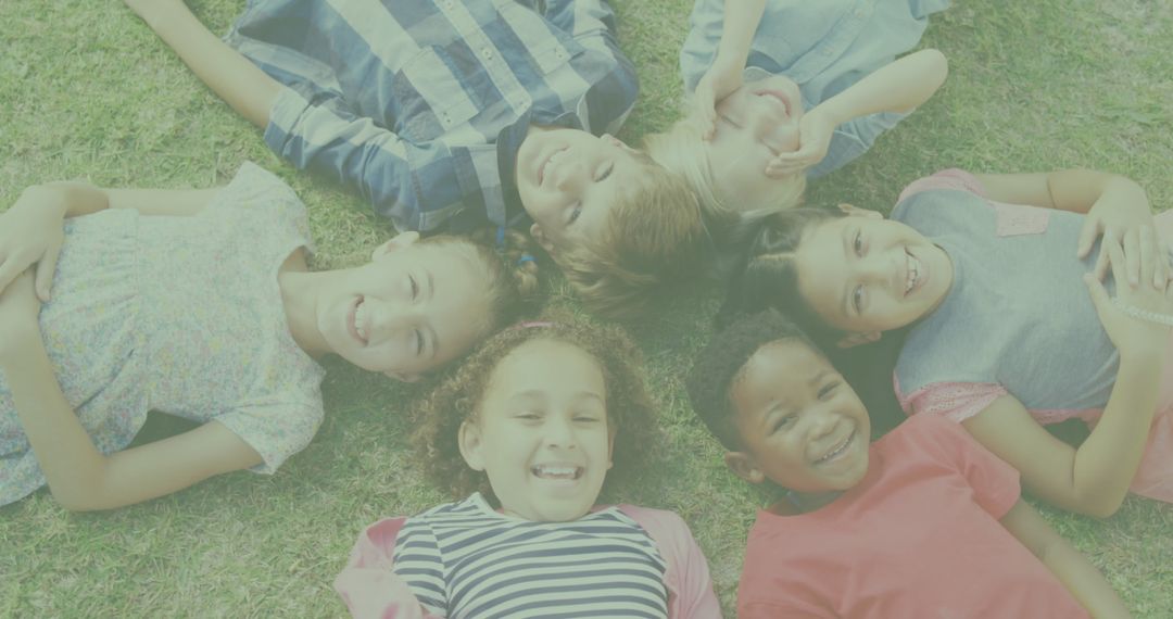 Joyful Children Lying on Grass Forming a Circle