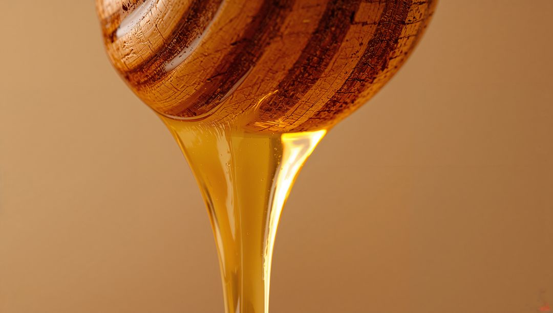 Golden Honey Dripping from Wooden Dipper Macro Close-Up Showing Viscous Glossy Texture