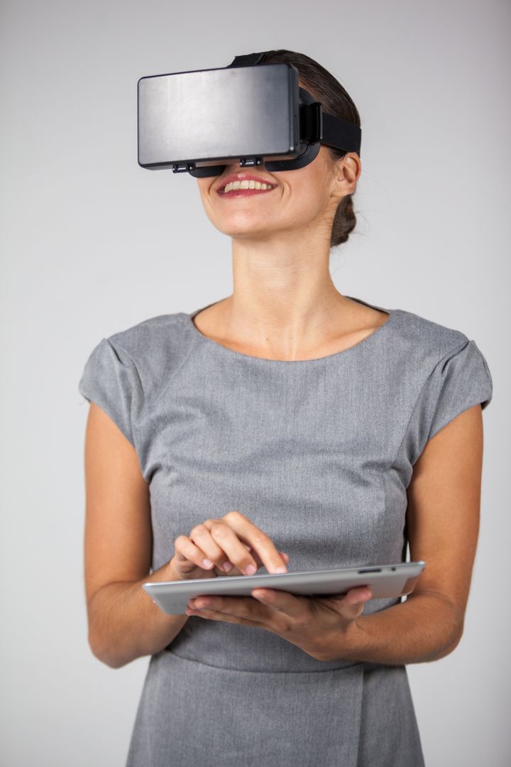 Woman holding digital tablet and using virtual reality headset - Free Images, Stock Photos and Pictures on Pikwizard.com