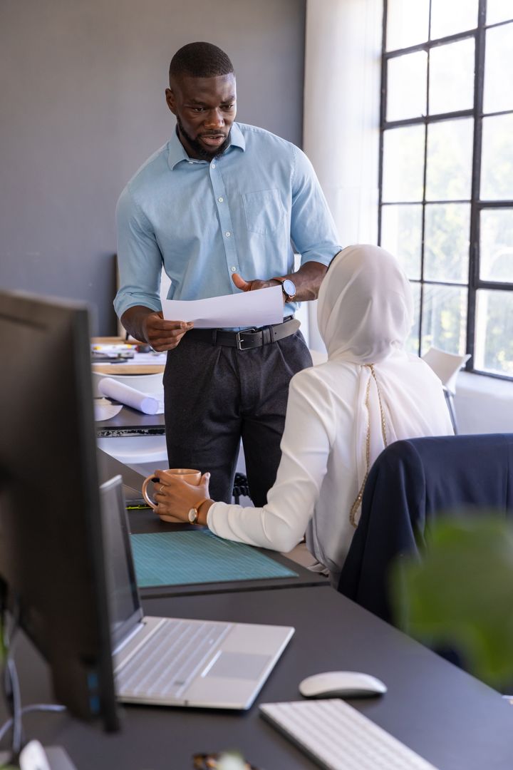 Diverse Colleagues Discussing Plans at Modern Office Workstation