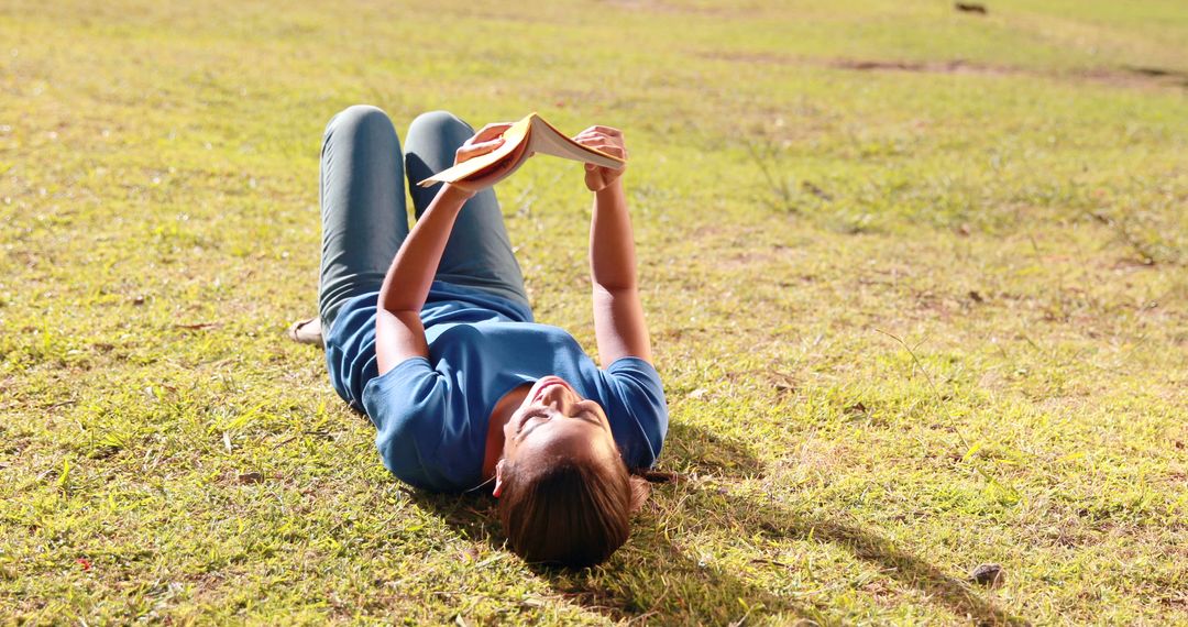 Young Woman Reading Book Outdoors on Sunny Day - Free Images, Stock Photos and Pictures on Pikwizard.com