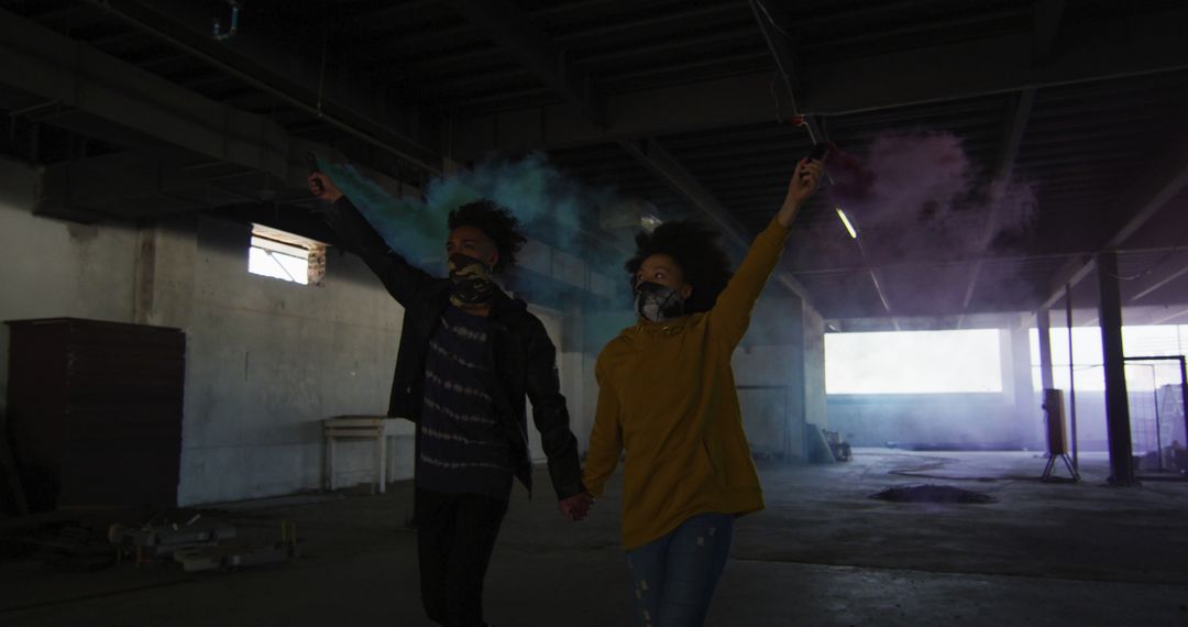 Young Couple Holding Smoke Flares in Urban Warehouse - Free Images, Stock Photos and Pictures on Pikwizard.com