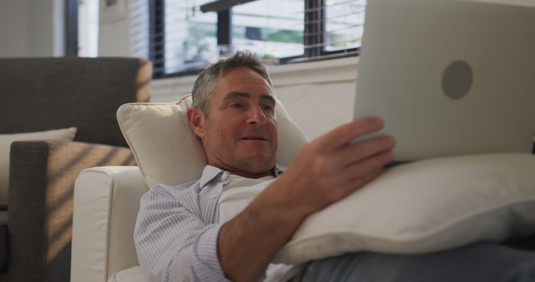 Middle-aged Man Relaxing on Couch Using Tablet at Home - Free Images, Stock Photos and Pictures on Pikwizard.com