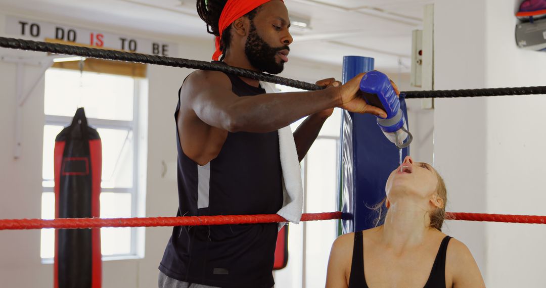 Boxing Trainer Helping Female Boxer Hydrate in Gym - Free Images, Stock Photos and Pictures on Pikwizard.com