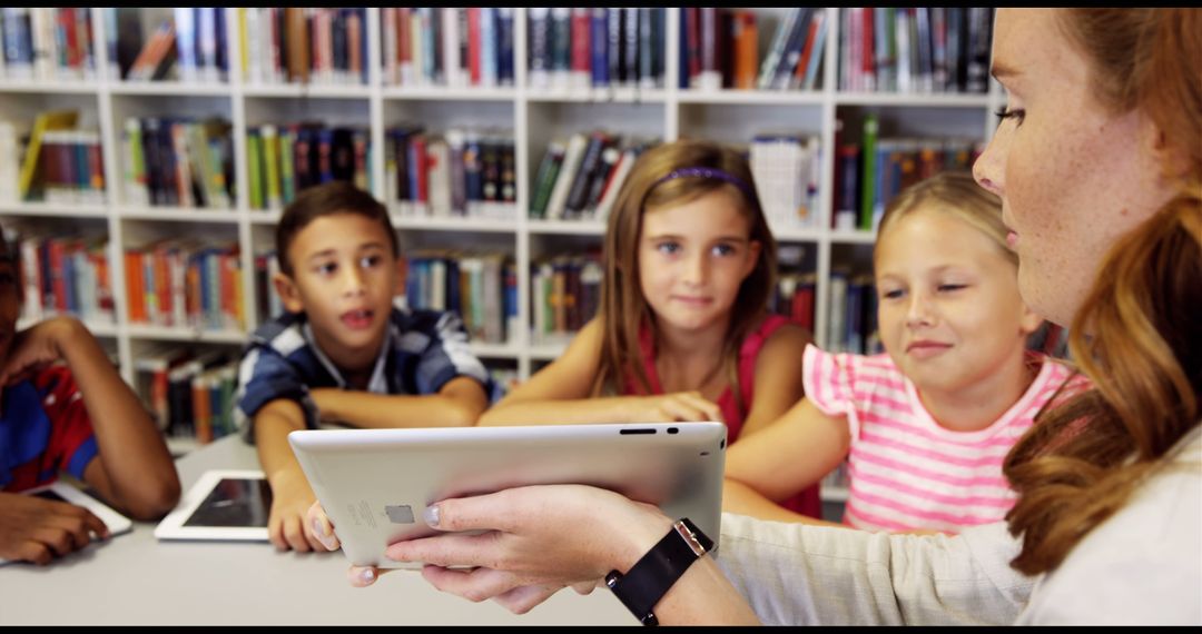 Teacher Using Tablet with Engaged Students in Library - Free Images, Stock Photos and Pictures on Pikwizard.com