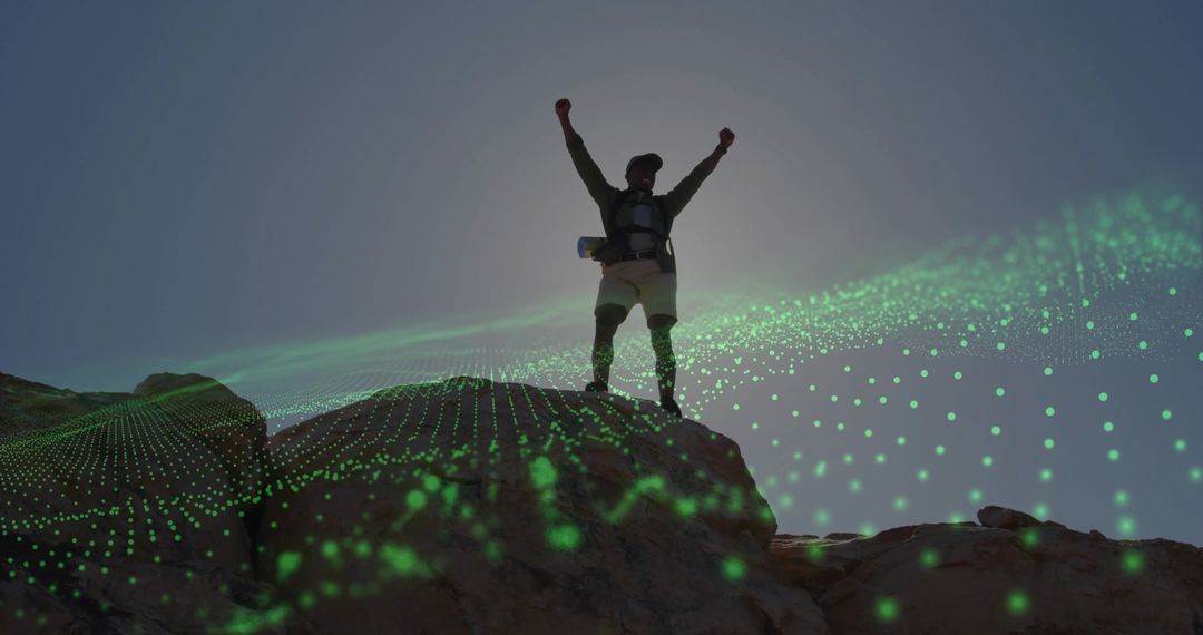 Silhouetted Hiker Raising Arms on Rocky Summit with Green Digital Mesh Overlay Celebrating Triumph