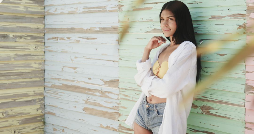 Young Woman Posing in Casual Beachwear Against Weathered Wooden Wall - Free Images, Stock Photos and Pictures on Pikwizard.com