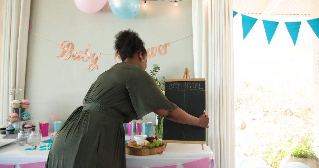 Woman Setting Up Baby Shower with Chalkboard Setup