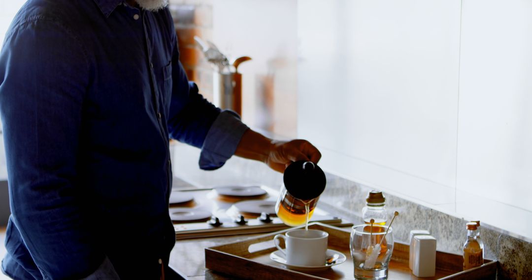 Man Pouring Coffee into Cup in Kitchen During Breakfast - Free Images, Stock Photos and Pictures on Pikwizard.com