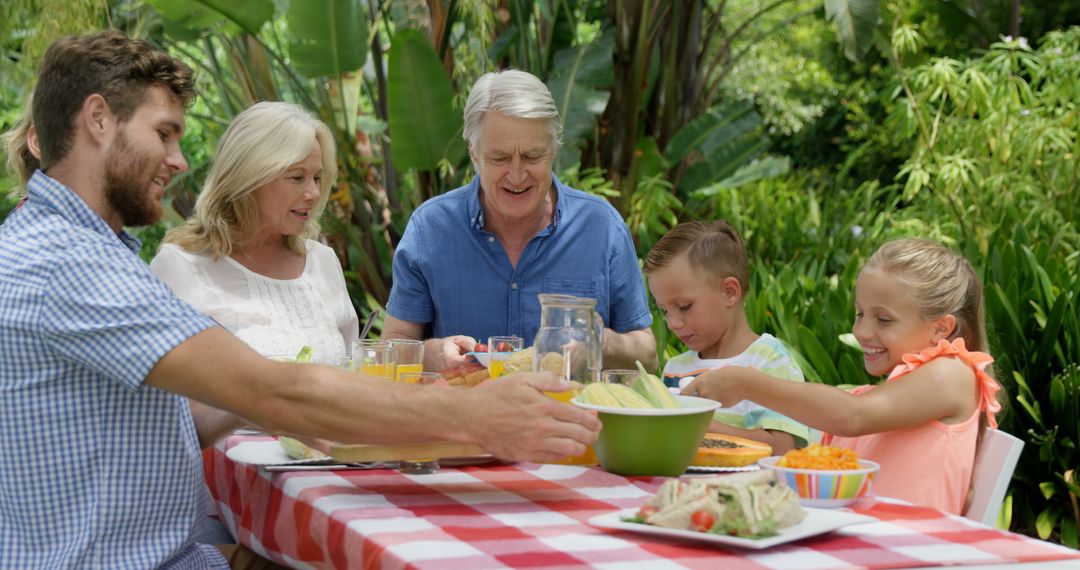 Happy Family Having Outdoor Lunch in Garden - Free Images, Stock Photos and Pictures on Pikwizard.com