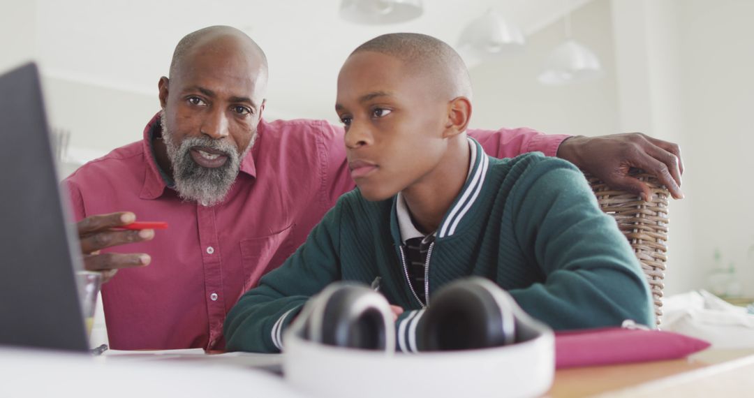 Image of happy african american father and son doing homework together - Free Images, Stock Photos and Pictures on Pikwizard.com