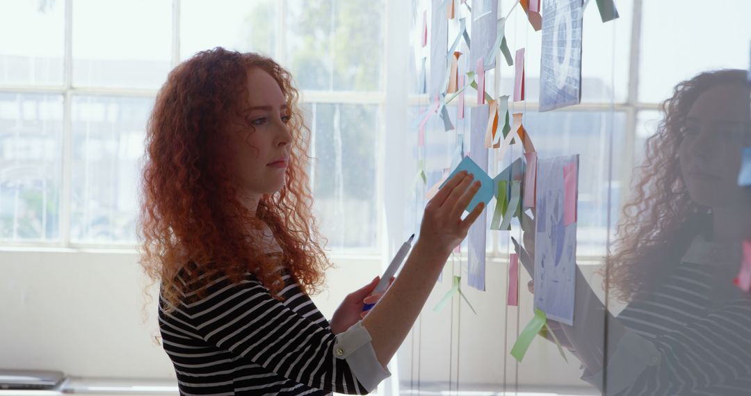 Young Woman Organizing Sticky Notes on Office Board - Free Images, Stock Photos and Pictures on Pikwizard.com