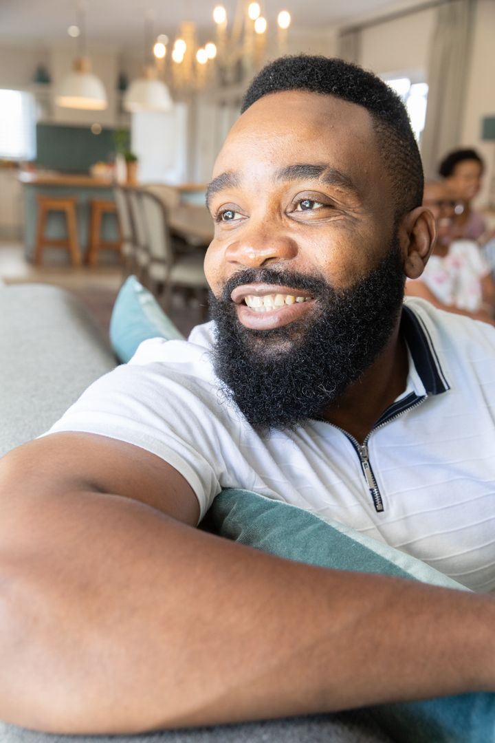 Smiling Man Relaxing on a Sofa in Modern Home Interior