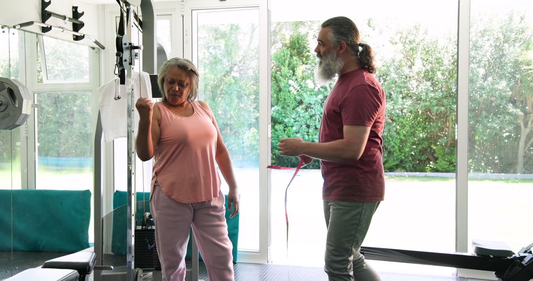 Senior Couple Exercising Together Using Gym Equipment