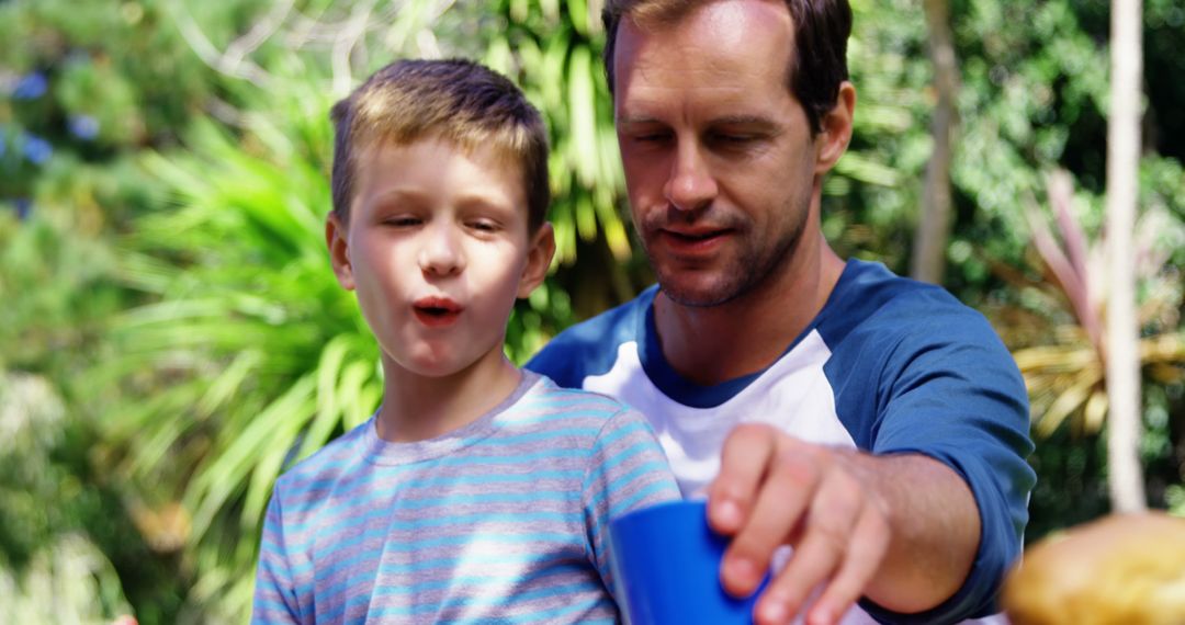 Father and Son Enjoying Outdoor Picnic on Sunny Day - Free Images, Stock Photos and Pictures on Pikwizard.com