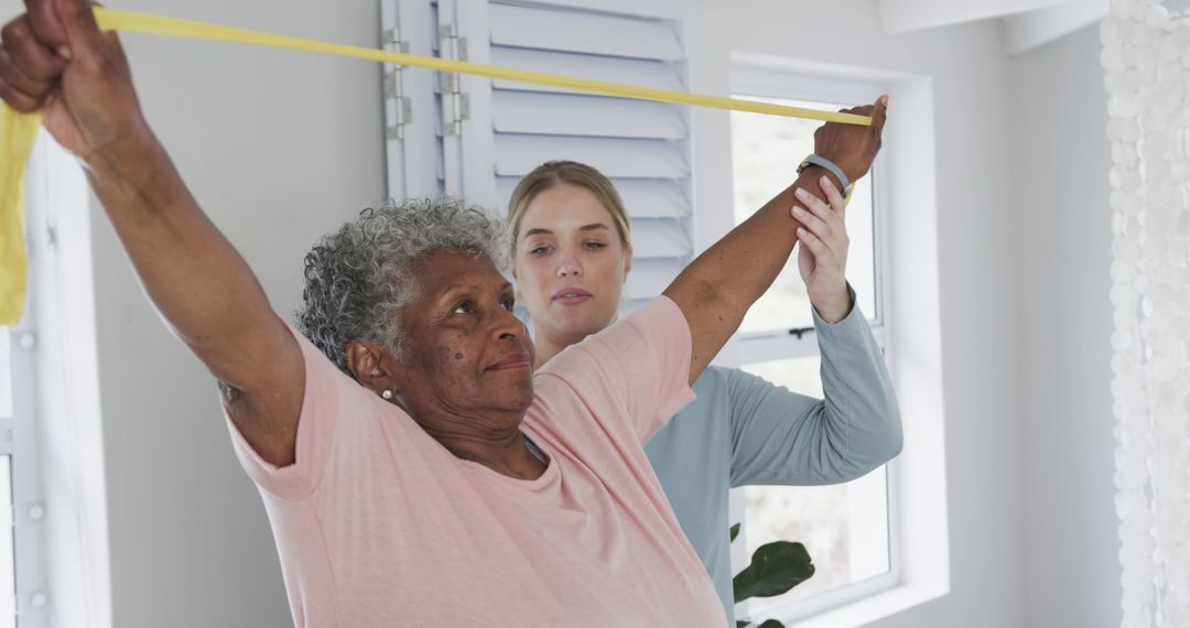 Senior woman exercising with resistance band guided by physical therapist - Free Images, Stock Photos and Pictures on Pikwizard.com