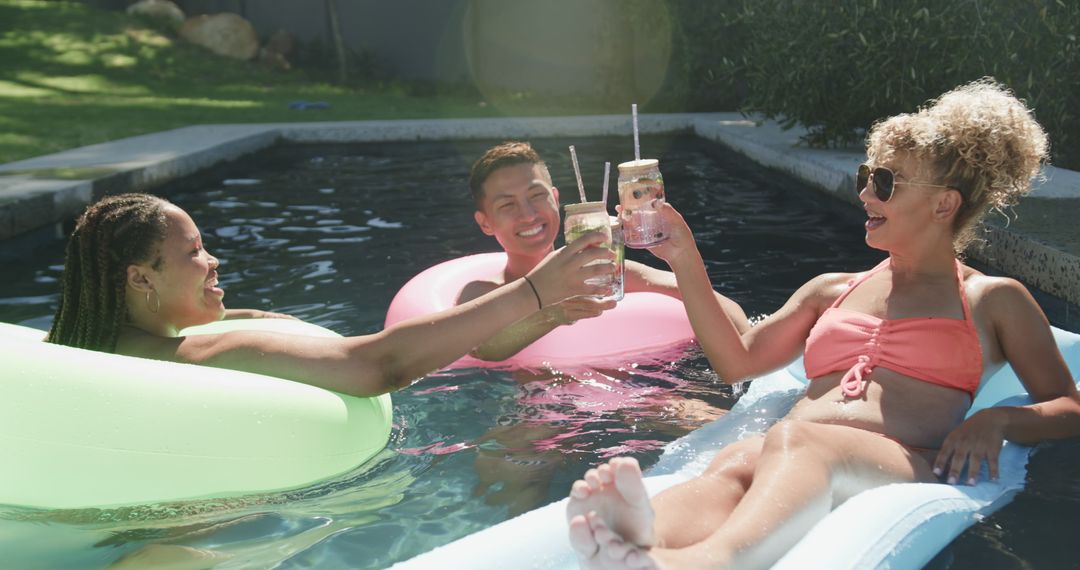 Friends Relaxing in Pool with Beverages on Sunny Day