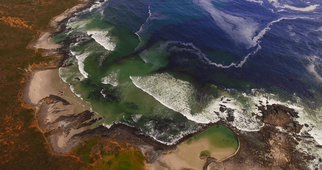Breathtaking Aerial View of Rugged Coastline Over Crystal Waters