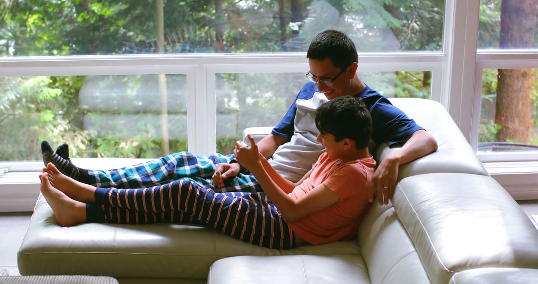 Father and Son Bonding on Couch with Digital Tablet - Free Images, Stock Photos and Pictures on Pikwizard.com