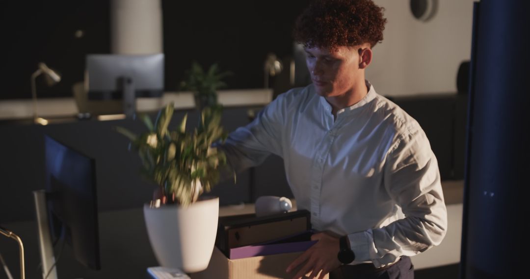 Man Packing Office in Evening Under Stressful Circumstances