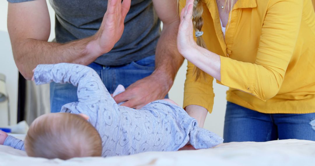 Parents Sharing Joyful Moment with Baby Giving High-Five - Free Images, Stock Photos and Pictures on Pikwizard.com