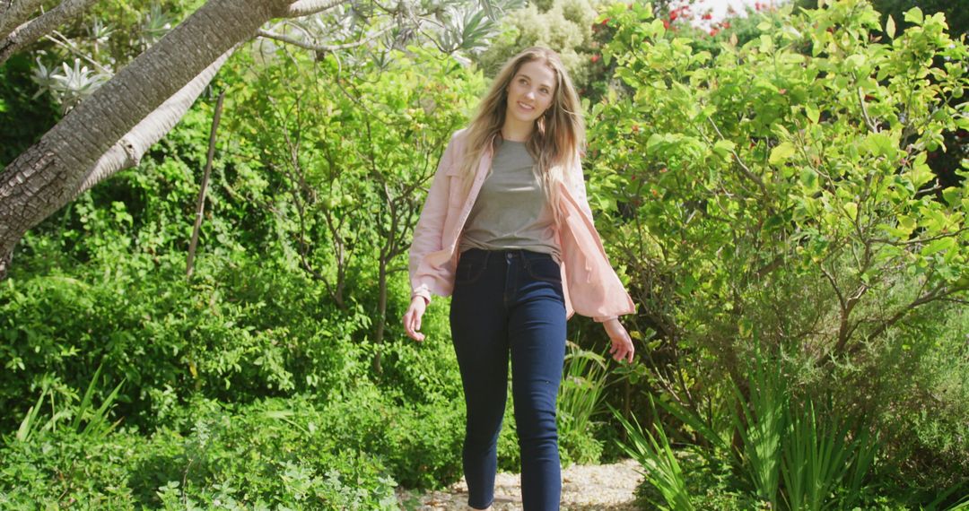 Happy Woman Strolling Through Lush Garden on Sunny Day