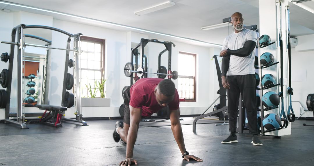 Personal Trainer Guiding Client in Functional Training Session at Gym