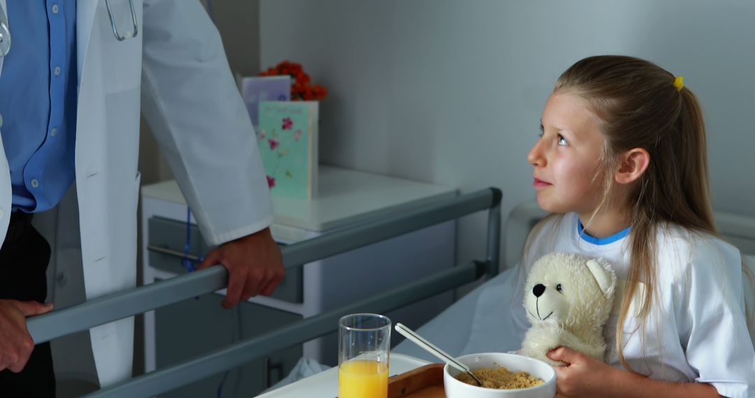 Young Girl Holding Teddy Bear in Hospital Bed Talking with Doctor - Free Images, Stock Photos and Pictures on Pikwizard.com