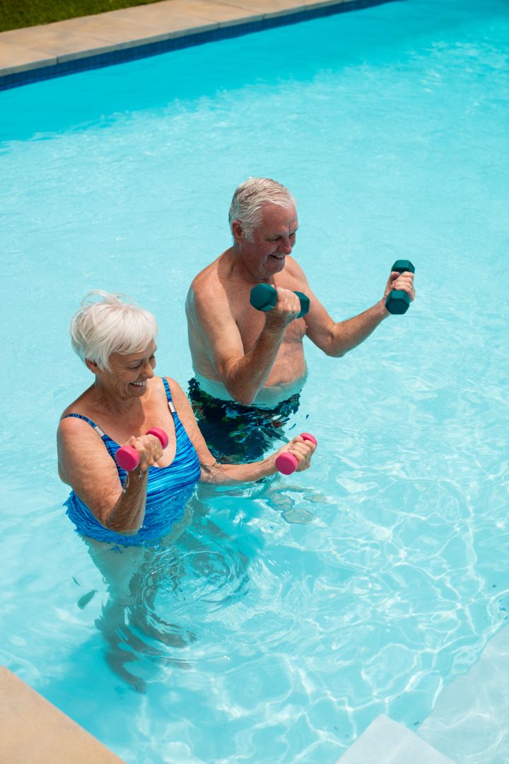 Senior couple exercising with dumbbells in the pool - Free Images, Stock Photos and Pictures on Pikwizard.com