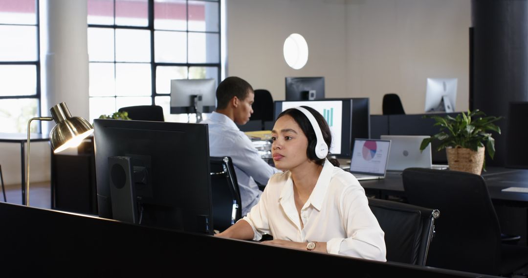 Focused Professionals Analyzing Data on Computers in Modern Office