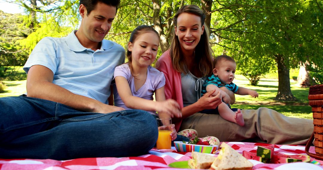 Young Family Enjoying Picnic Outdoors Under Bright Sun - Free Images, Stock Photos and Pictures on Pikwizard.com