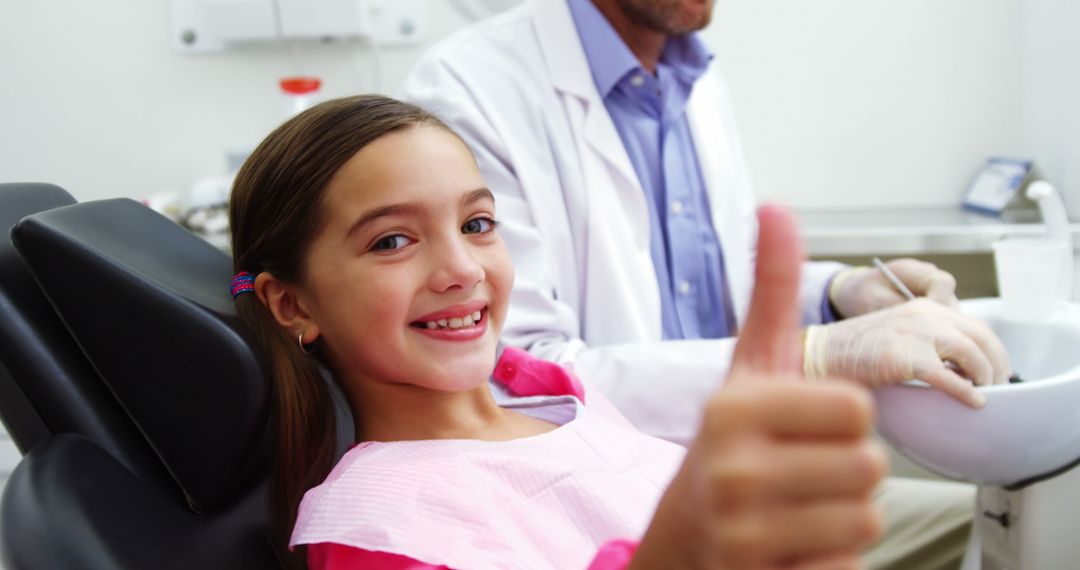 Smiling Young Girl Giving Thumbs Up at Dental Clinic - Free Images, Stock Photos and Pictures on Pikwizard.com