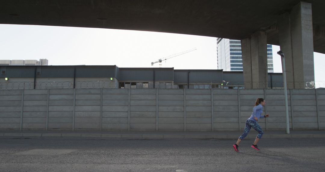 Woman Running on Urban Road under Bridge - Free Images, Stock Photos and Pictures on Pikwizard.com