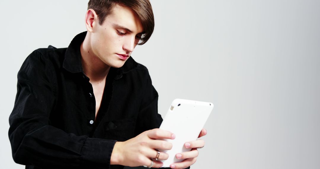 Young Man With Tablet Wearing Black Shirt against White Background - Free Images, Stock Photos and Pictures on Pikwizard.com