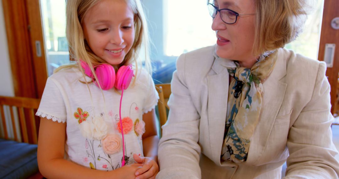 Little Girl Wearing Pink Headphones Interacting With Teacher - Free Images, Stock Photos and Pictures on Pikwizard.com